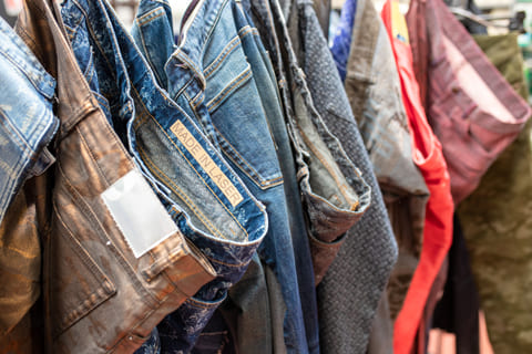 Jeans customised with the laser, hanging on a rack